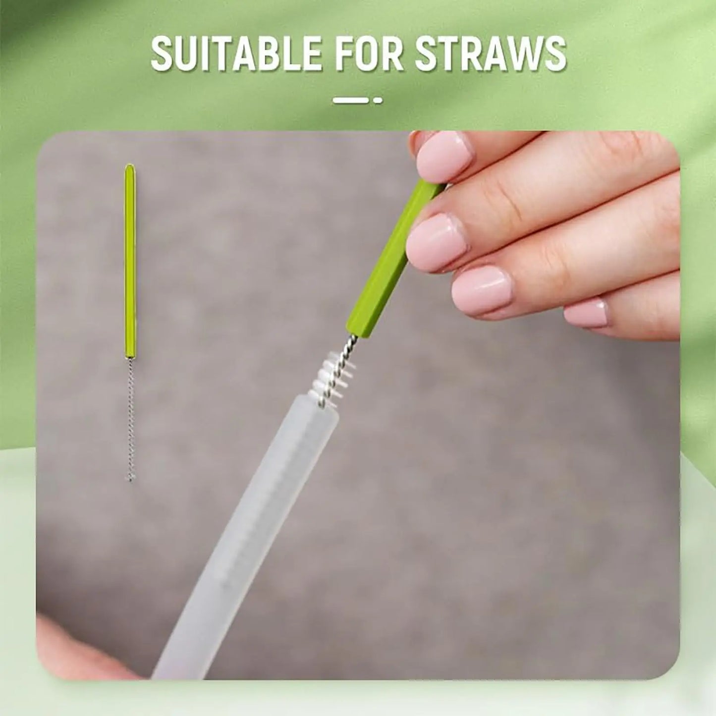 Hand holding a green straw cleaning brush with a clear straw on a gray surface, against a green background.