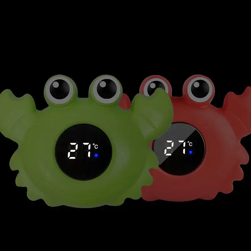Crab-shaped baby bath thermometers in green and red with digital 27Β°C display on black background