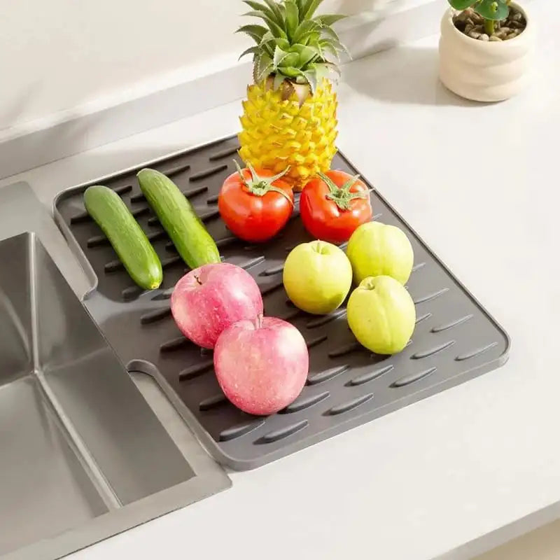 Gray silicon dish drying mat with fruits and vegetables on a kitchen counter