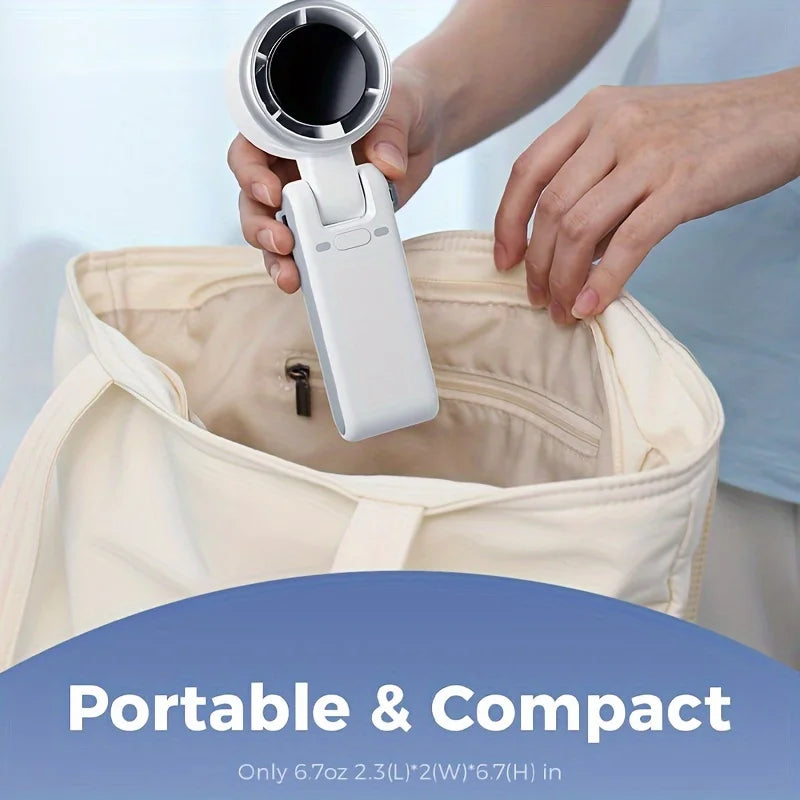 Person placing a compact white foldable turbo fan into a travel bag, highlighting its portable and lightweight design