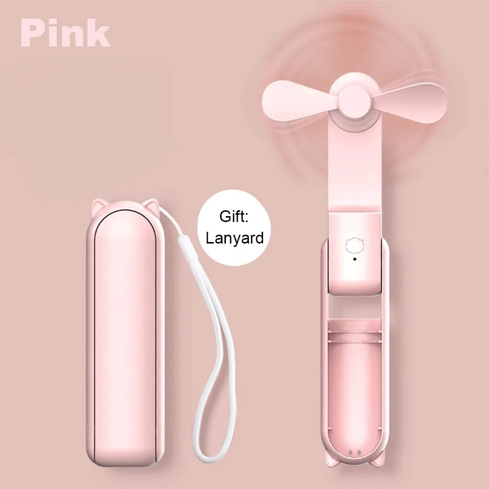 Pink handheld fan with carrying case and lanyard on a pink background