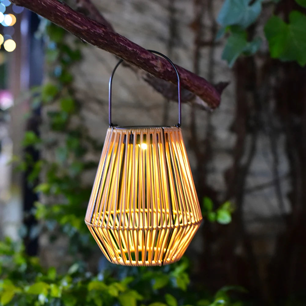 Wicker lantern hanging from a branch with a blurred garden background