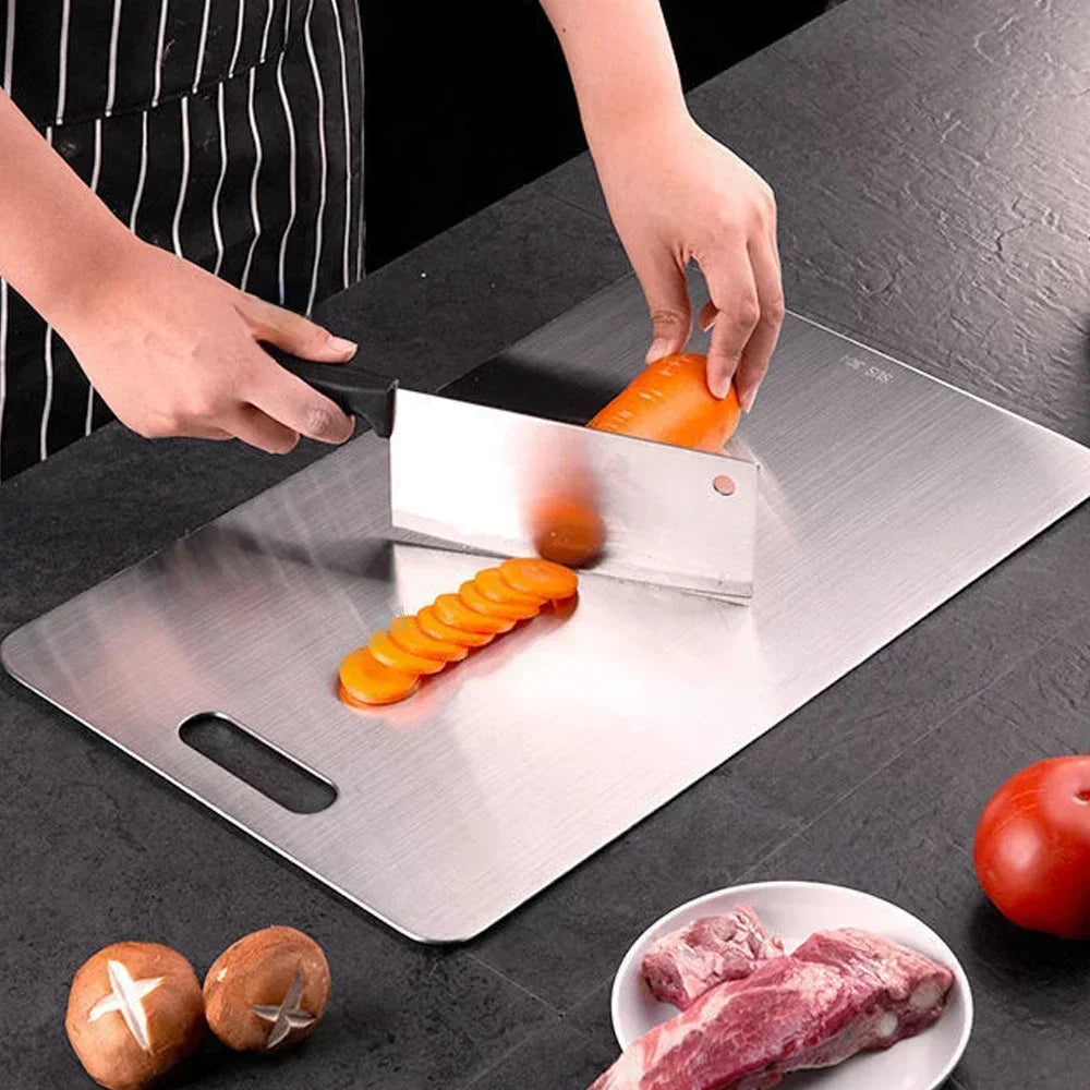 person cutting vetegables on the stainless steel cutting board