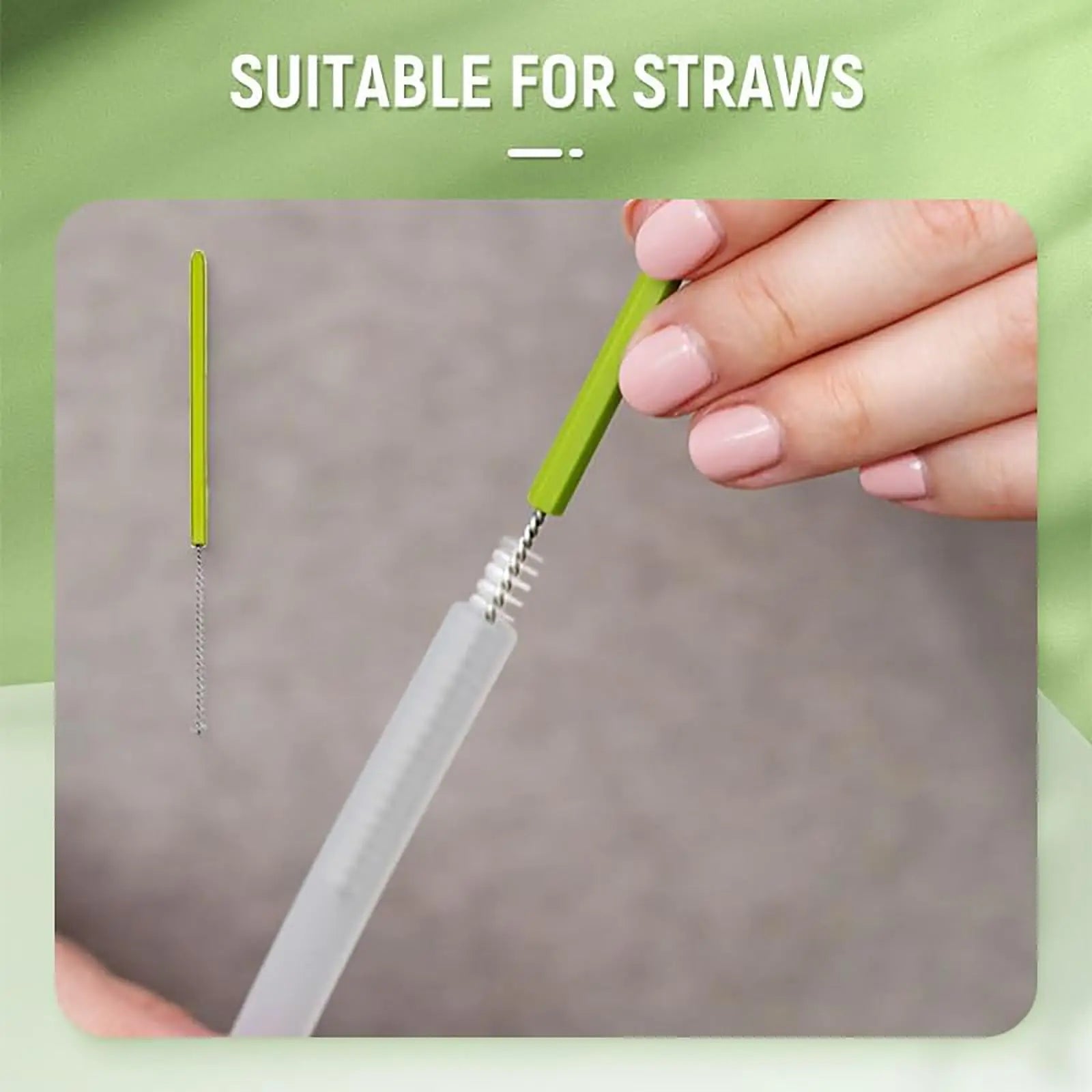 Hand holding a green straw cleaning brush with a clear straw on a gray surface, against a green background.