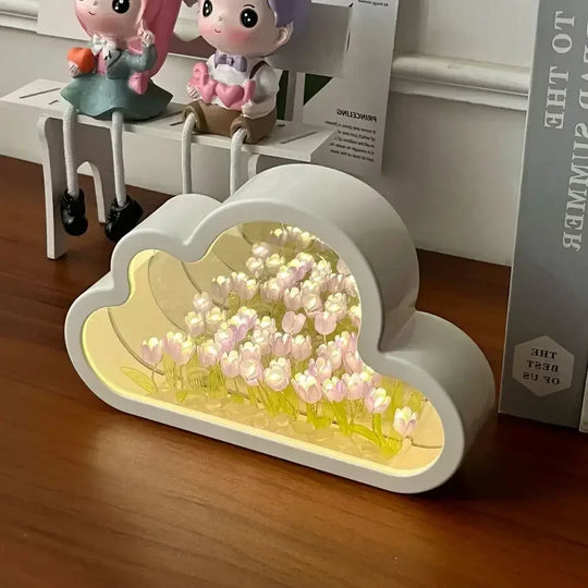Cloud-shaped DIY Tulip Flower Garden Light Box with glowing white blooms and mirrored background, placed on a wooden desk
