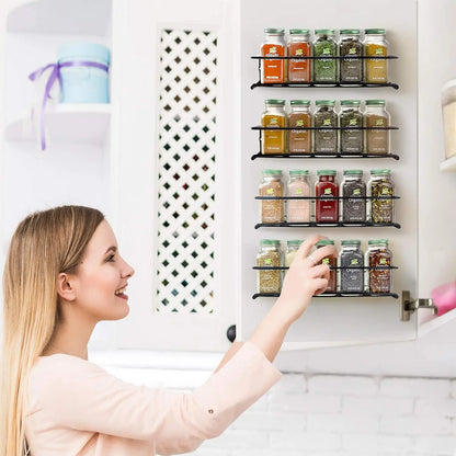 Kitchen spice storage rack mounted inside cabinet with labeled jars