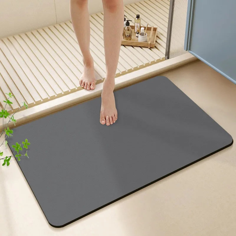 Person stepping onto a gray bath mat in a bathroom setting.