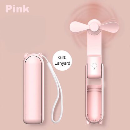 Pink handheld fan with carrying case and lanyard on a pink background