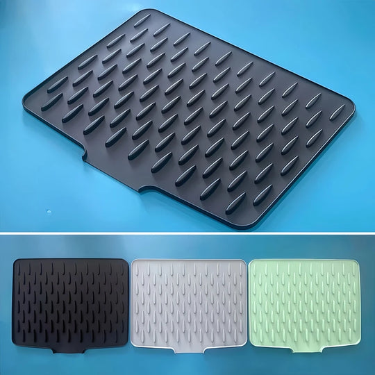 Black textured silicon drying mat on a blue background with additional mats in black, white, and green shown below.
